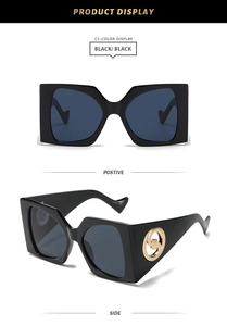 Detail of oversized square sunglasses with gold rotating logo and wavy temple design