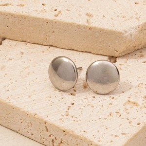 Detailed view of round polished 304 stainless steel stud earrings on stone