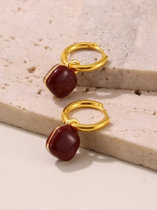 Close-up of elegant 18k gold plated hoop earrings with glossy deep red square pendants