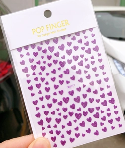 Detailed view of Me017 3D purple glitter heart nail stickers in clear retail packaging