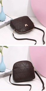 Detail of dark brown shell bag with geometric quilt stitching and bow metal ornament