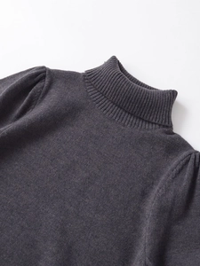 Close-up of ribbed high collar and pleated puff sleeves on dark grey knit top