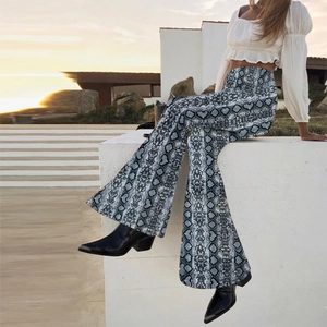 Detailed outdoor shot of high-waisted snake print flared trousers in grey and black