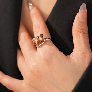 Detailed view of rocking horse ring crafted from silver metal and wood on a finger