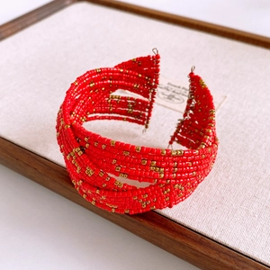 Detail of red and gold beaded wide cuff bracelet with multi-layer woven texture