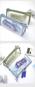 Macro shot of transparent PVC pencil case with reinforced blue and green fabric zippers