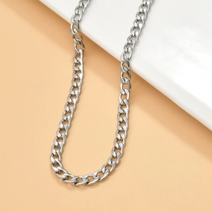 Detailed view of glossy silver Cuban link chain on a white ceramic display stand