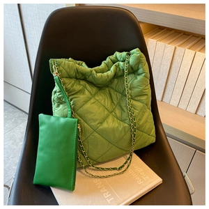 Dettaglio della borsa tote verde trapuntata con tracolla a catena e pochette abbinata