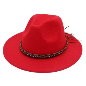 Dettaglio di cappello fedora rosso in feltro con fascia di strass e nappa in pelle