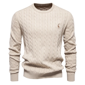 Detail of beige cable knit sweater showing deer embroidery and premium fabric texture