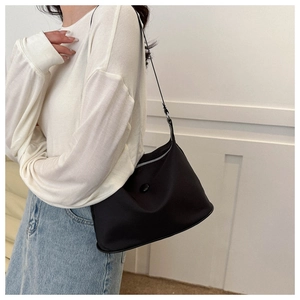 Gros plan du sac à bandoulière en nylon noir avec détails argentés sur un mannequin