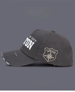 Close-up of distressed charcoal grey baseball cap with 3D embroidery and compass patch