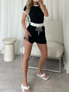 Detail of black two-piece set featuring white contrast binding and elastic drawstring waist