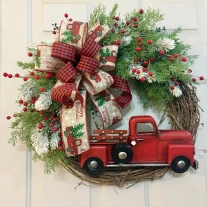 Detail of red truck Christmas wreath with pine needles and red black plaid bow