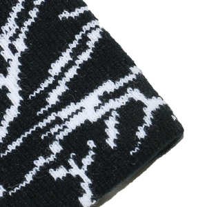 Macro view of heavy knit beanie fabric with striking black and white jagged pattern texture