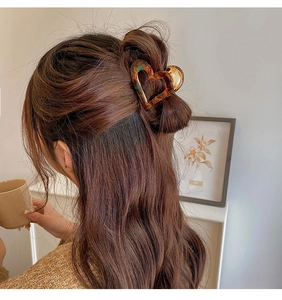 Détail d'une pince à cheveux cœur en écaille pour une coiffure demi-attachée femme