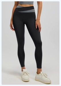 Detalle de mallas de yoga de talle alto con diseño de cintura cruzada en color gris