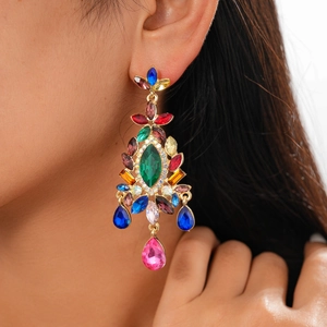 Close-up of vintage gold earrings with colorful crystals worn by a female model