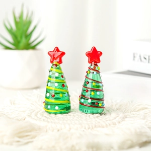 Detail of miniature glass Christmas trees with red stars on a woven decorative mat