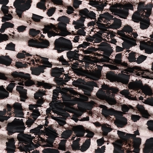 Close-up of leopard print fabric featuring ruched texture and soft polyester material