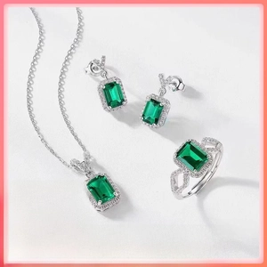 Close-up of emerald cut green gemstone jewelry set with necklace, earrings and ring