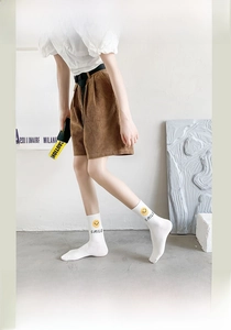 Detailed close-up of white crew socks with yellow smiley face and smile lettering