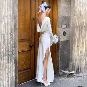 Elegant white backless evening dress with high side slit and long sleeves detail