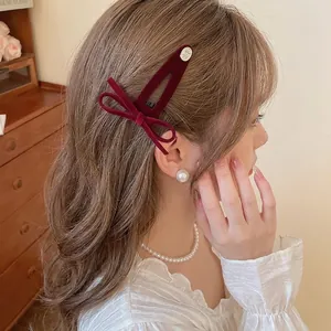 Elegant deep red velvet bow hair clip for women styled on long wavy brown hair