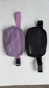 Detail view of purple and black nylon waist bags with adjustable straps and logo print