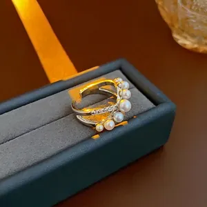 Elegant silver cross ring featuring round white pearls and zircon accents on a velvet box