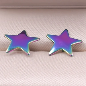 Macro shot of colorful iridescent star stud earrings in a soft pink silk jewelry box