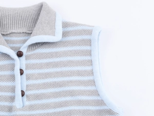 Dettaglio del gilet in maglia a righe grigio-blu con bottoni marrone scuro e colletto