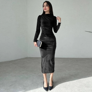 Full view of black velvet long sleeve midi dress with matching clutch and heels