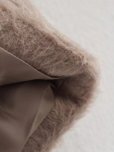 Detailed macro view of soft wool blend fabric and inner lining in light coffee brown