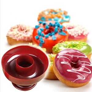 Dettaglio dello stampo per ciambelle in plastica rossa con ciambelle colorate sullo sfondo
