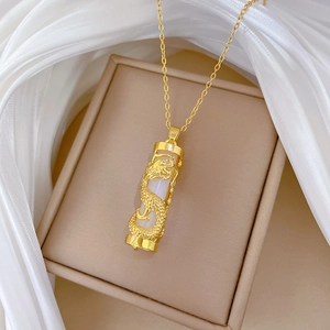 Elegant gold dragon necklace with white jade pillar pendant on luxury jewelry box