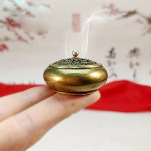 Macro di un mini bruciatore di incenso in ottone antico con coperchio traforato