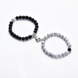 Detail of magnetic heart clasp connecting matte black and white marble bead bracelets