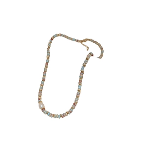 Collier artisanal de perles colorées avec un pendentif perle blanche sur fond blanc