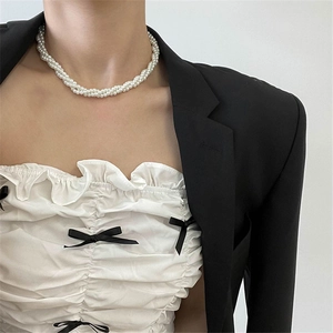Detail of multi-layer faux pearl choker necklace with twisted rope structure on model
