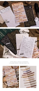 Macro view of vintage English quote stickers on dark wood background for journaling