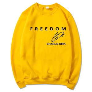 Detail of yellow sweatshirt featuring black Charlie Kirk signature and Freedom text