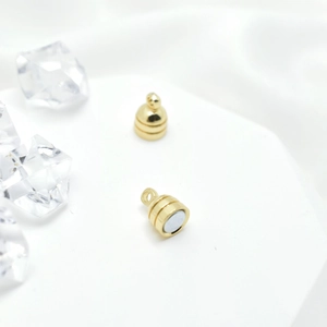 Golden magnetic jewelry clasps for necklaces on a clean white display with crystals