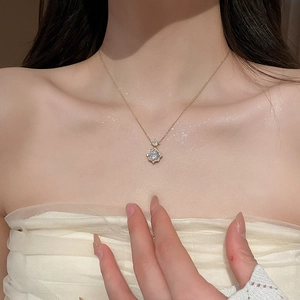 Detail of 14k gold plated necklace with a sparkling zircon rose pendant on a model