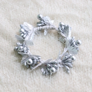 Silver Christmas berry and leaf napkin ring with sequins on white plush background
