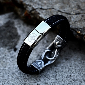 Close-up of black braided leather bracelet with viking star magnet clasp and snake charm