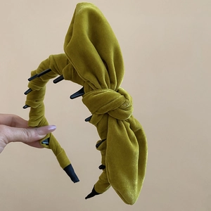 Close-up of olive green velvet knotted headband with black anti-slip inner teeth