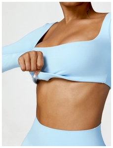 Detail shot of light blue yoga top showing high-elasticity fabric stretch and square neck