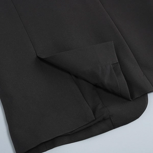 Close-up of side slit hem and stitching on a black casual rhinestone blazer jacket