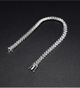 Close-up of silver tennis bracelet with cubic zirconia on a textured black background